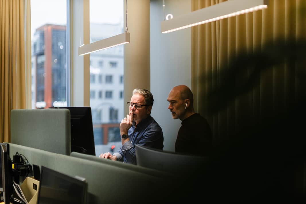 Två män som sitter framför en datorskärm.