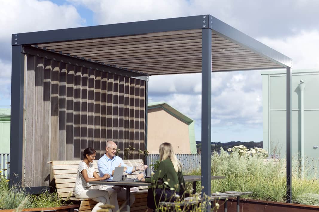 Tre personer på en utomhusarbetsplats.