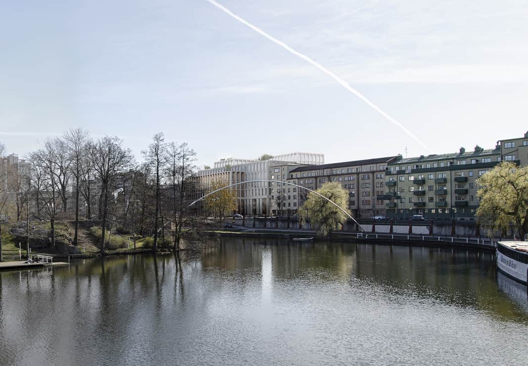 Å i förgrunden och så sticker den nya fastigheten upp vid kanten av ån.