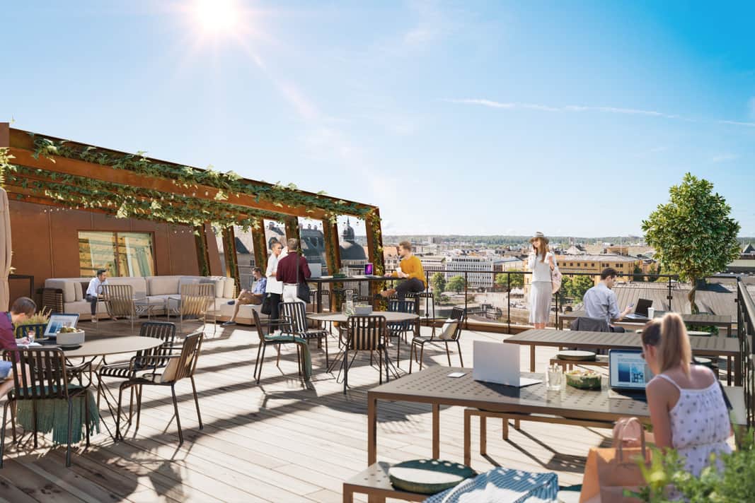 Möbler och människor som sitter och jobbar och umgås i solen på takterassen