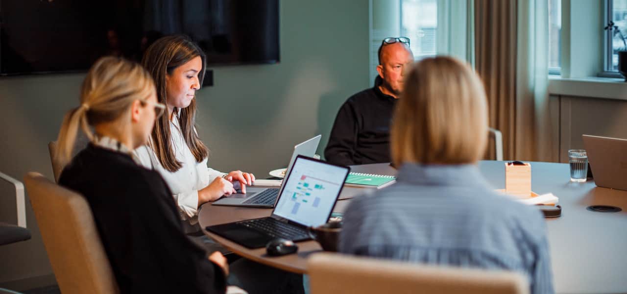 Människor sitter vid ett konferensbord.