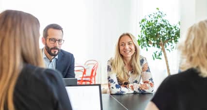 Four people sitting at a table, engaged in conversation.