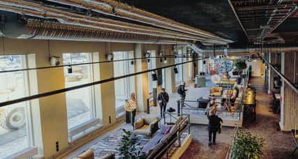 Personer sitter i en foajé. 