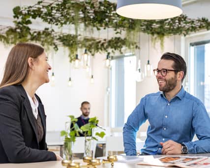 Två personer samtalar vid ett bord.