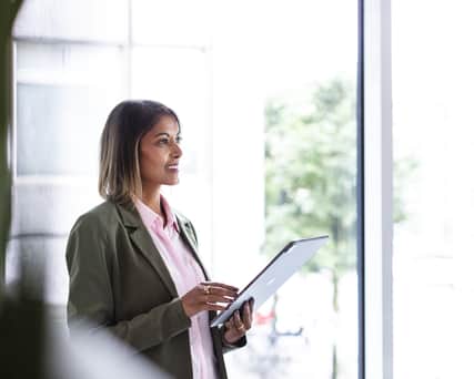 Två personer står och tittar på en ipad.
