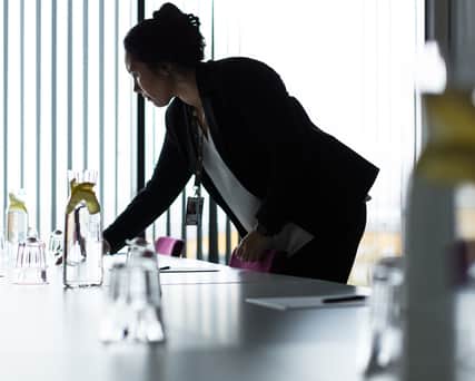 Person som gör iordning ett konferensbord.