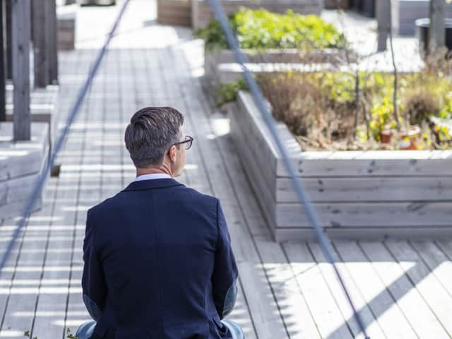 Person som sitter på en bänk utomhus.