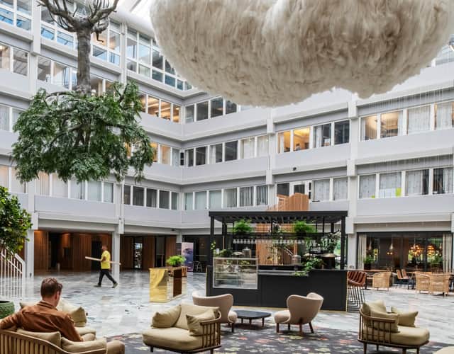 Vy över atrium med ett träd hängandes upp och ner i taket.