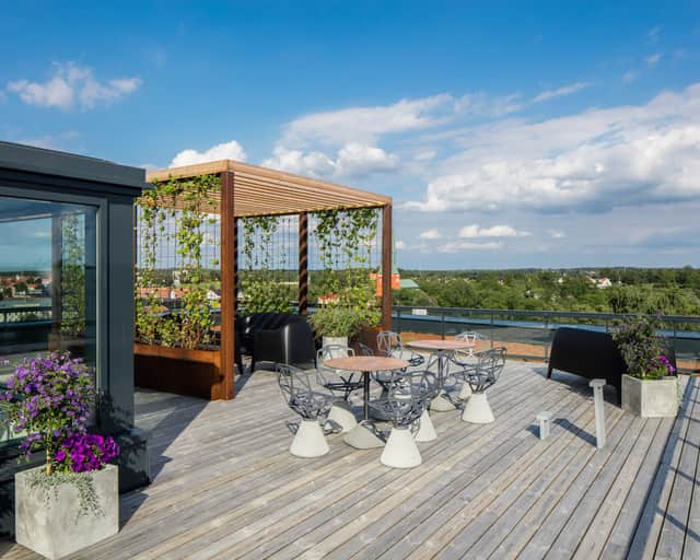 Takterass med pergola och stolar.