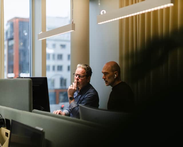 Två män som sitter framför en datorskärm.