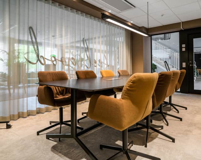 Mötesrum med bruna stolar.