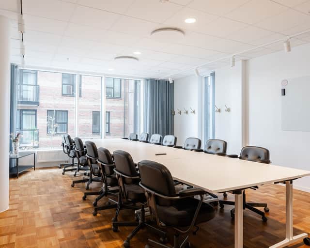 Ett konferensrum med ett långt bord och stolar.