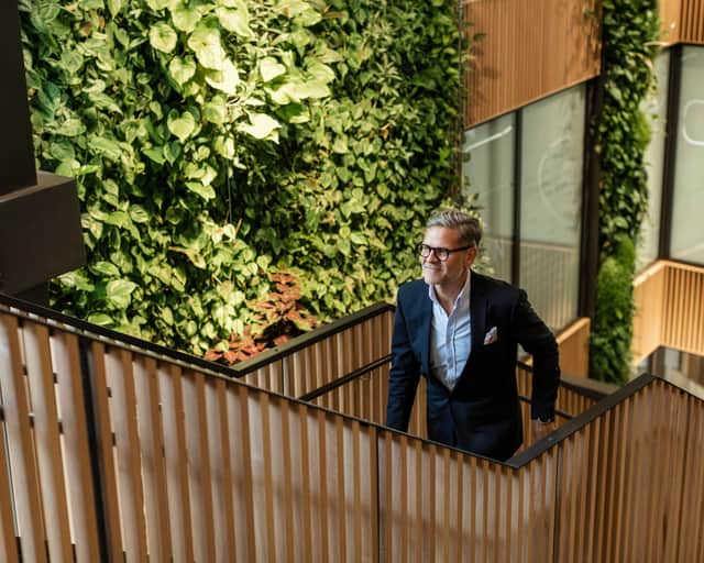 Interiörbild med en soffa och bord i förgrunden och en vägg och restaurang i bakgrunden. 