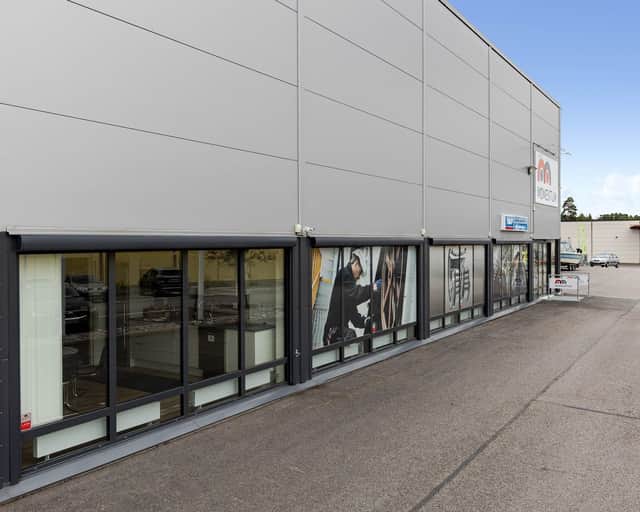 Vy över en del av en fastighet med butiksfönster på marknivå