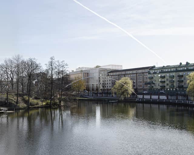 Å i förgrunden och så sticker den nya fastigheten upp vid kanten av ån.