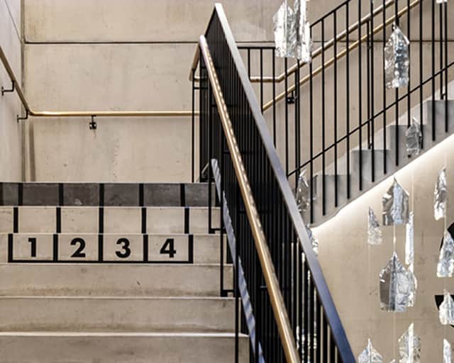 Trappa med utsmyckningar och svart räcke.