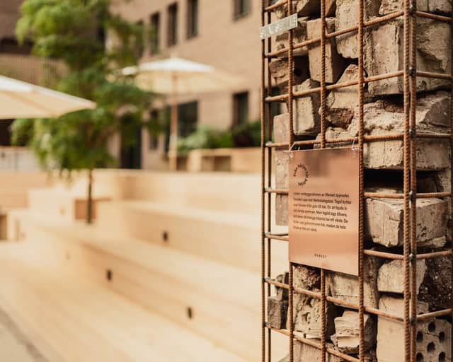 Ihopsamlade tegelstenar från renoveringen ligger i en armeringsnätkorg ute på Atriumgården