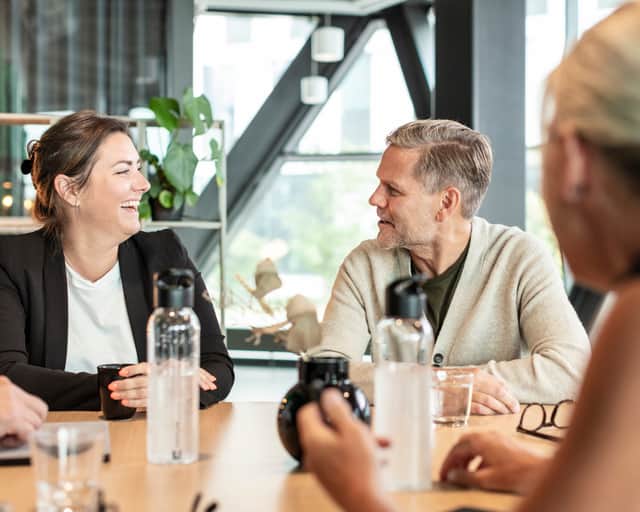 en kvinna och en man sitter vid ett bord, vända mot varandra och är glada