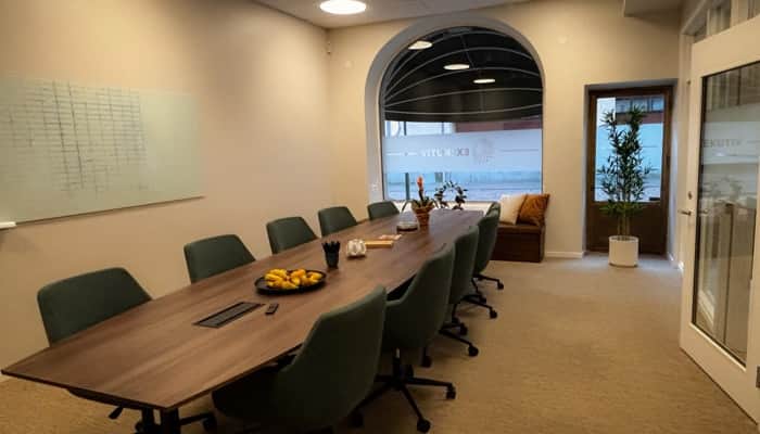 Ett konferensrum med ett långt bord och fönster