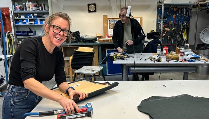 En kvinna och en man syns arbeta vid ett bord med några verktyg.