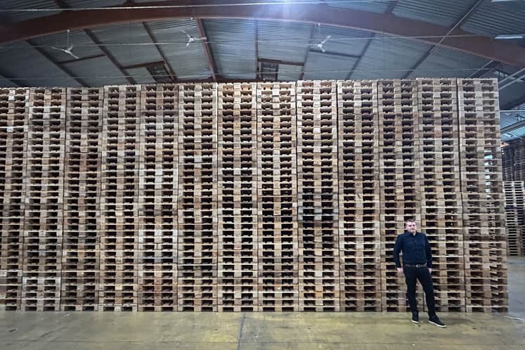 Henrik Lundqvist står framför en vägg av pallar.