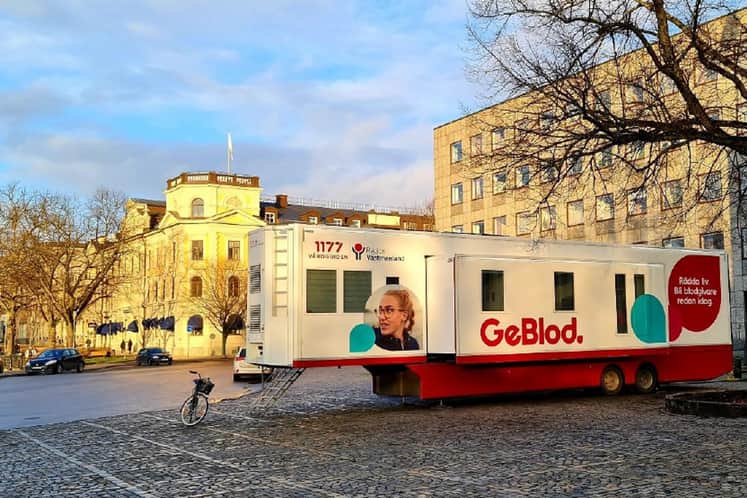 Blodgivarbuss som står på ett torg i eftermiddagssol