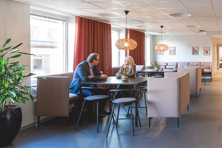 Två personer sitter i en matsal.