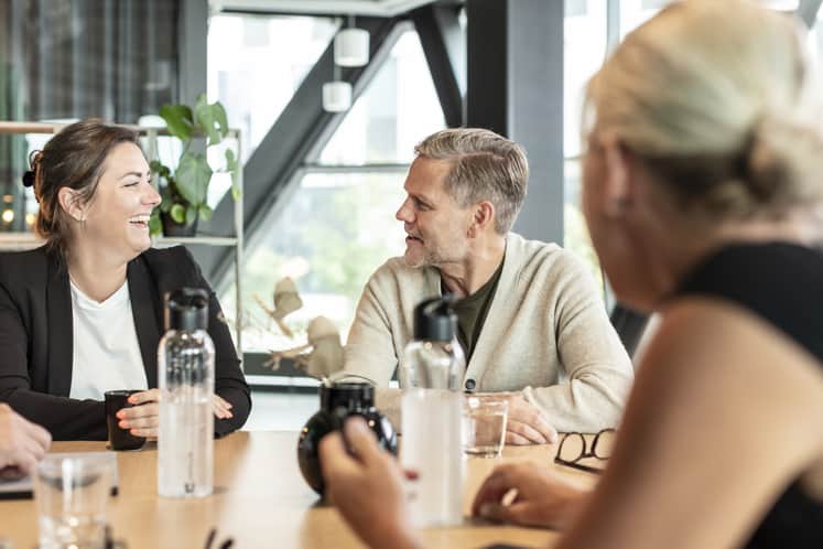 Kollegor som sitter och samtalar i en restaurangmiljö.