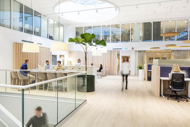 Öppet kontor med personer vid skrivbord.