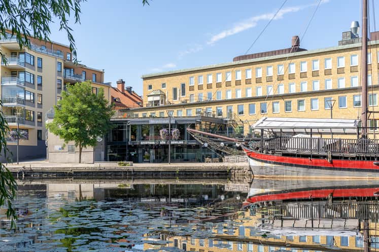 Vy över fastigheten med kanalen och en båt i förgrunden.