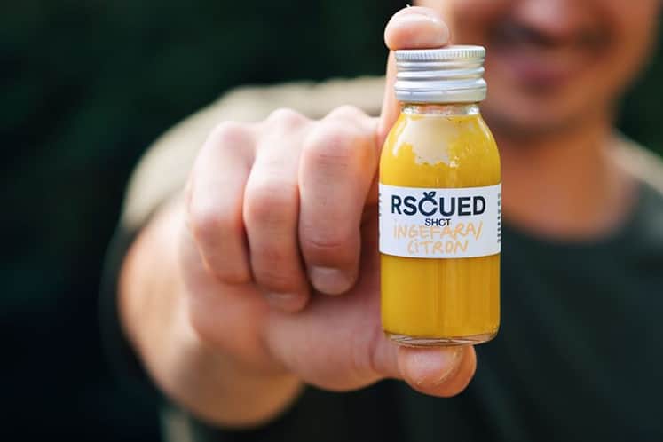 Hand som håller i en juiceflaska.