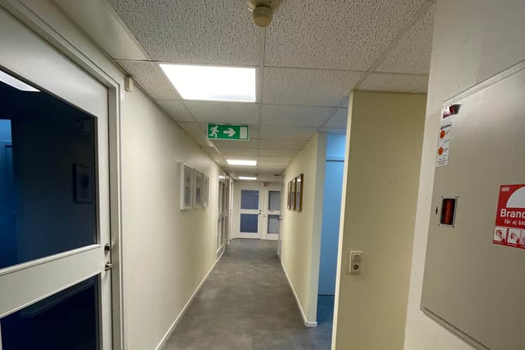 En lång korridor med en skylt på väggen.