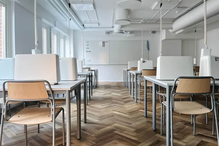 Ett klassrum där man ser stolar och bord i förgrunden och i bakgrunden ser man en whiteboard-tavla
