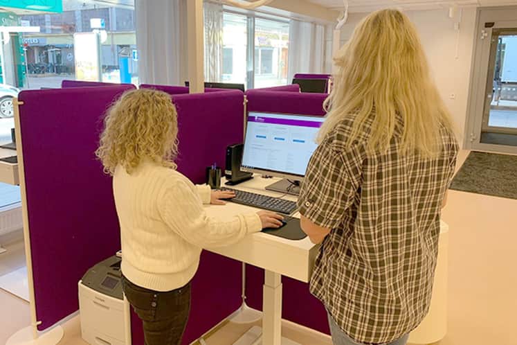 Två personer står vid ett skrivbord.