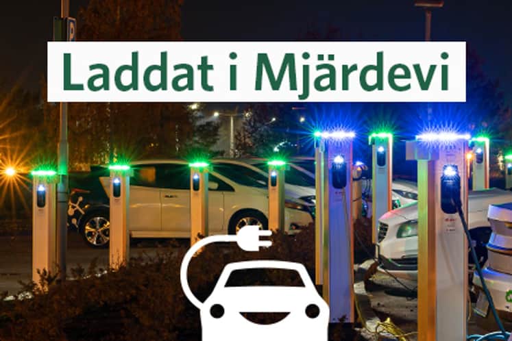 Kvällsbild på laddstolpar och bilar.