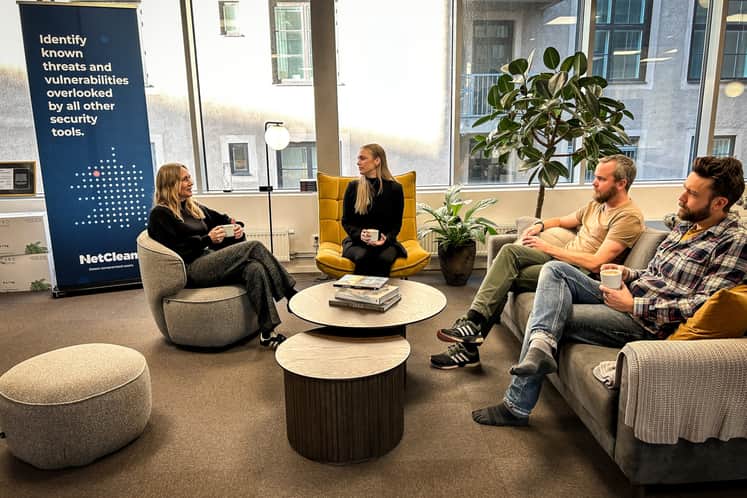 En grupp personer sitter i soffor och dricker kaffe.