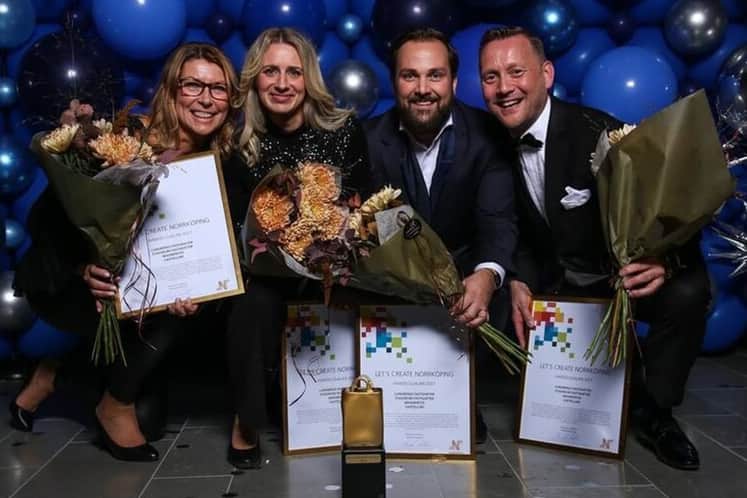 Prismottagarna med blommor och diplom.