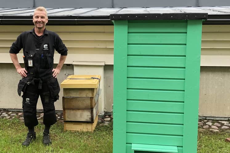 Roger står bredvid bikupor.