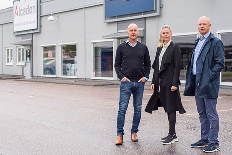 Theresia, Nicklas och Magnus framför en fastighet.