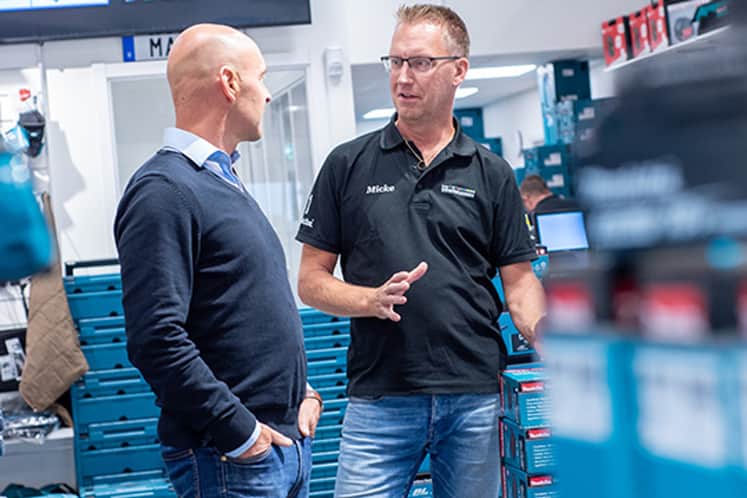 Mikael pratar med en kollega inne i butiken.