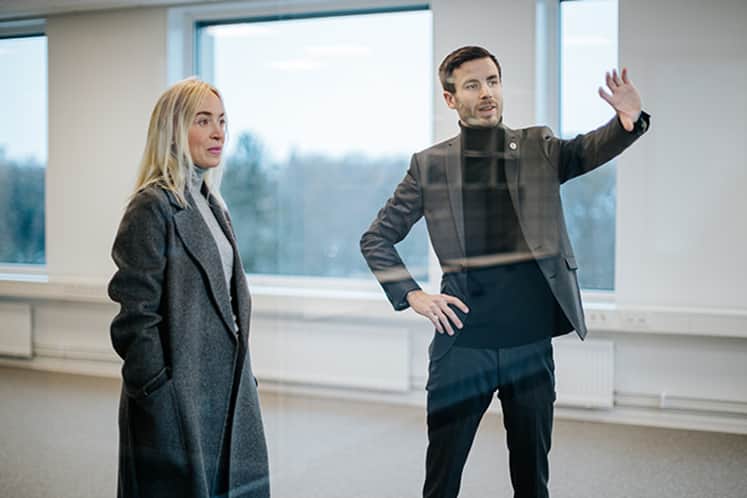 Två personer tittar ut genom ett fönster i lokalen.