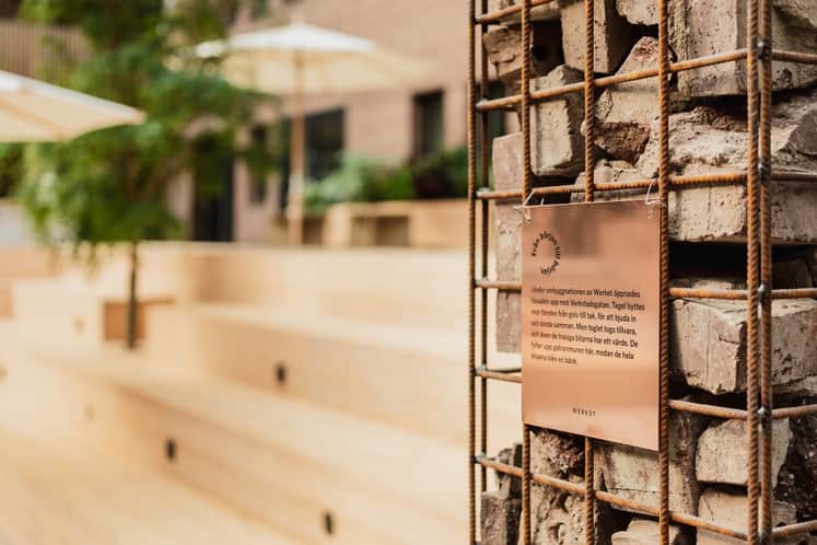 Bruna tegelstenar som ligger i en bur av armeringsnät. Stenarna är från tidigare väggar som rivits.