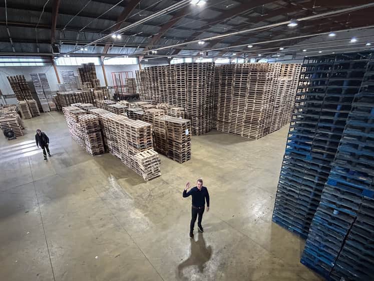 Stora högar med pallar i lagerlokal.