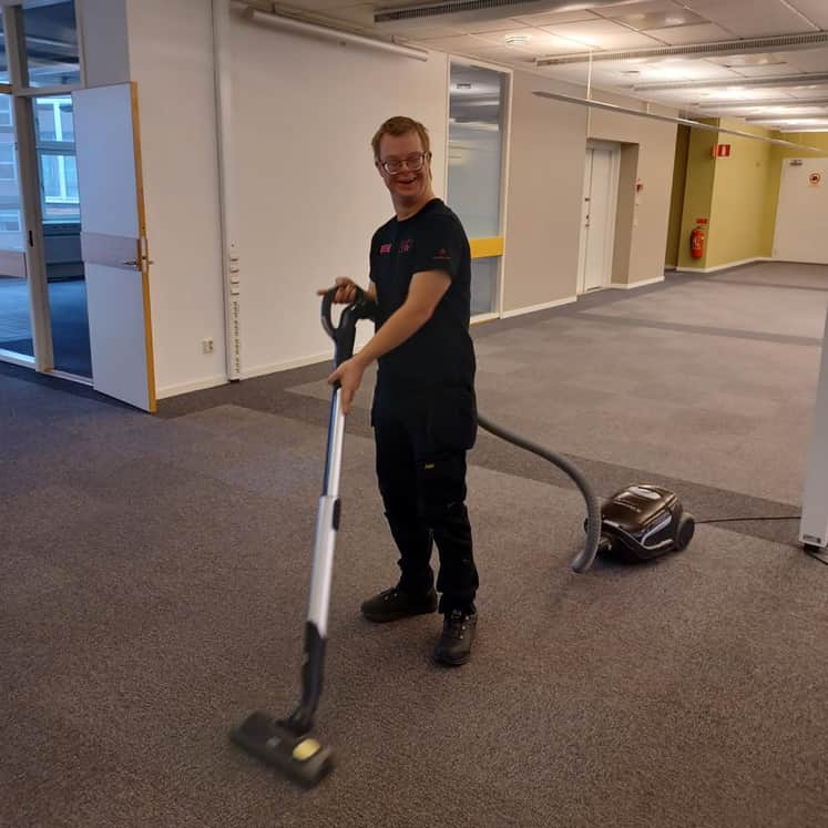 Anton dammsuger ett kontor.