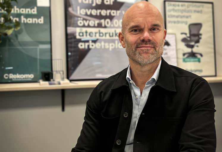 En man sitter vid ett bord på ett kontor.