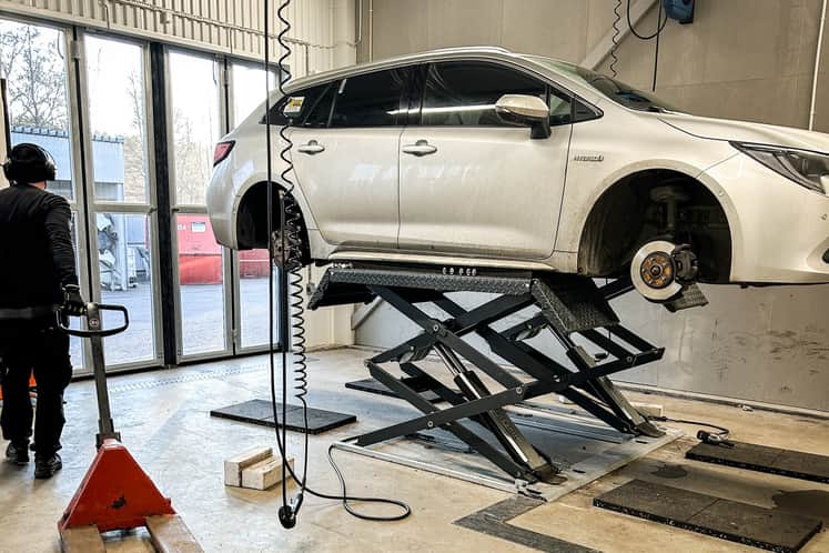 Verkstad med bil som hissats upp.