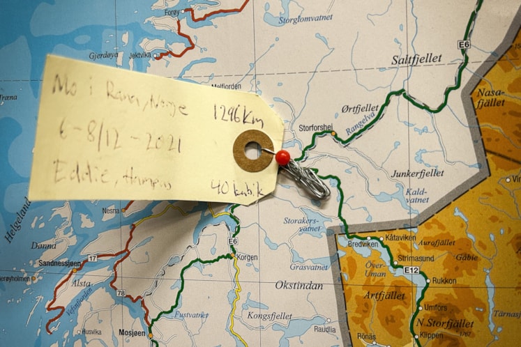 En karta. På kartan sitter en lapp med information gällande en flytt till Norge.