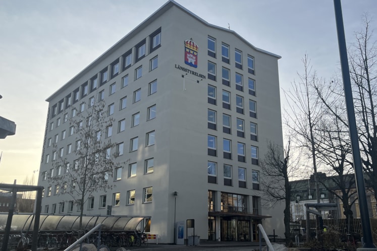 Vit fastighet med många små fönster 